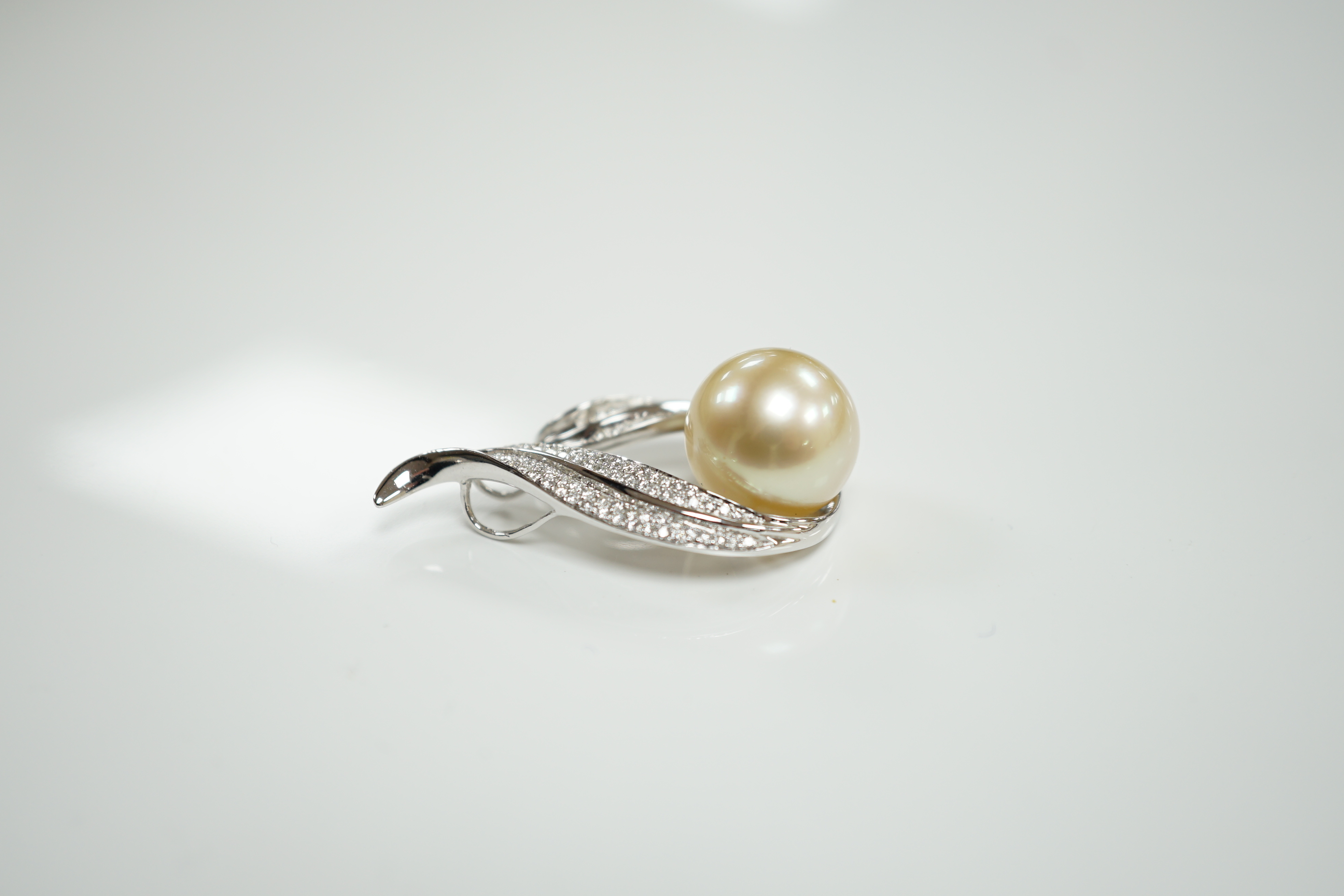 A modern 18ct white gold, single stone South Sea cultured pearl and diamond chip cluster set pendant, 32mm, gross weight 7.1 grams.